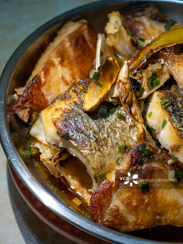 放在不锈钢餐盘里的香煎鱼肉图片素材