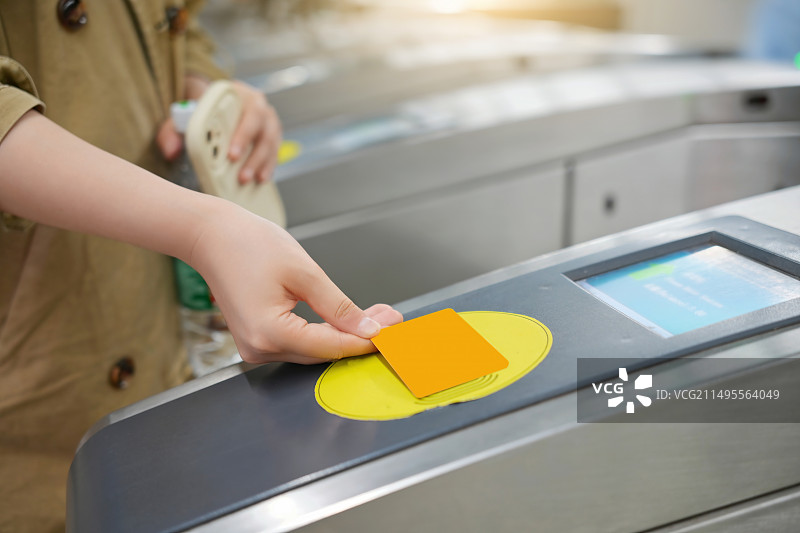 通勤者在地铁旋转栅门使用非接触式卡图片素材