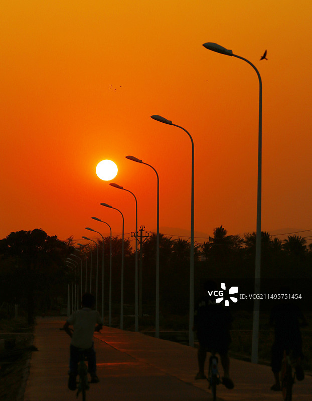 2024年4月27日，暮春夏初，夕阳下的海南三亚天涯区槟榔河村的乡间小路。图片素材