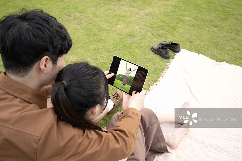 年轻的情侣在草坪上玩耍图片素材