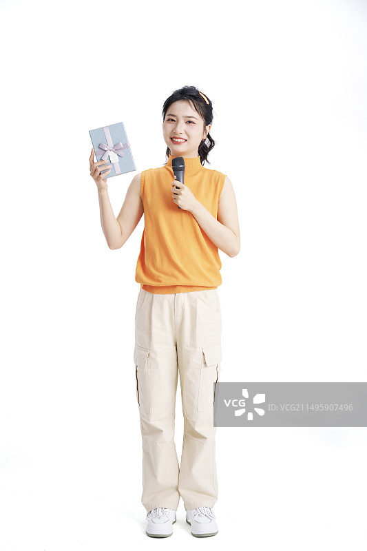 手拿话筒与礼盒的年轻女大学生图片素材