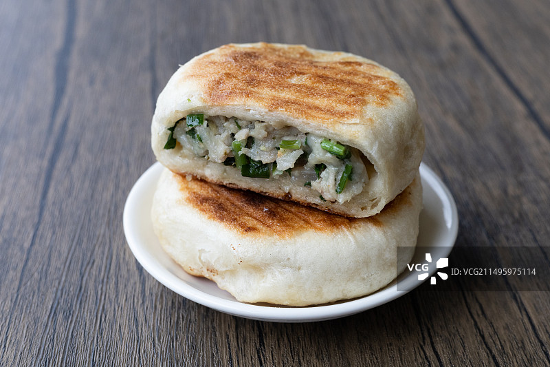 木纹桌面上的猪肉韭菜馅饼烙饼中国早餐美食静物特写图片素材