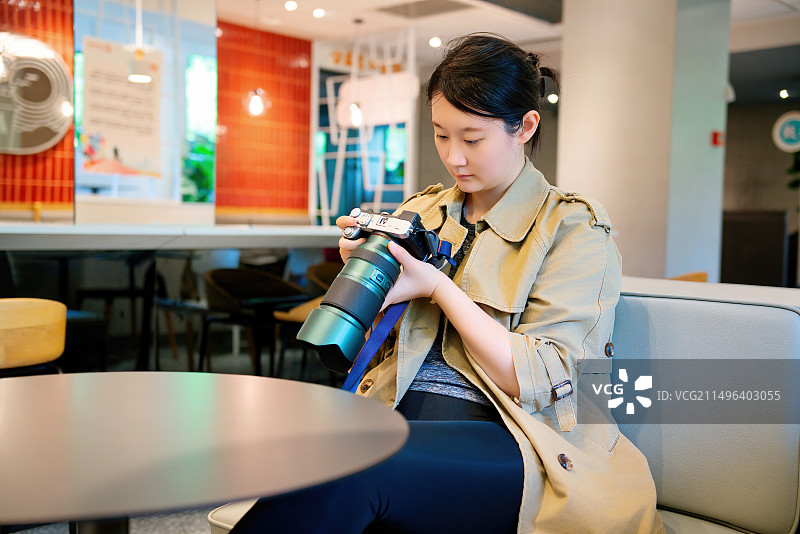 年轻女子在室内检查摄像头设置图片素材