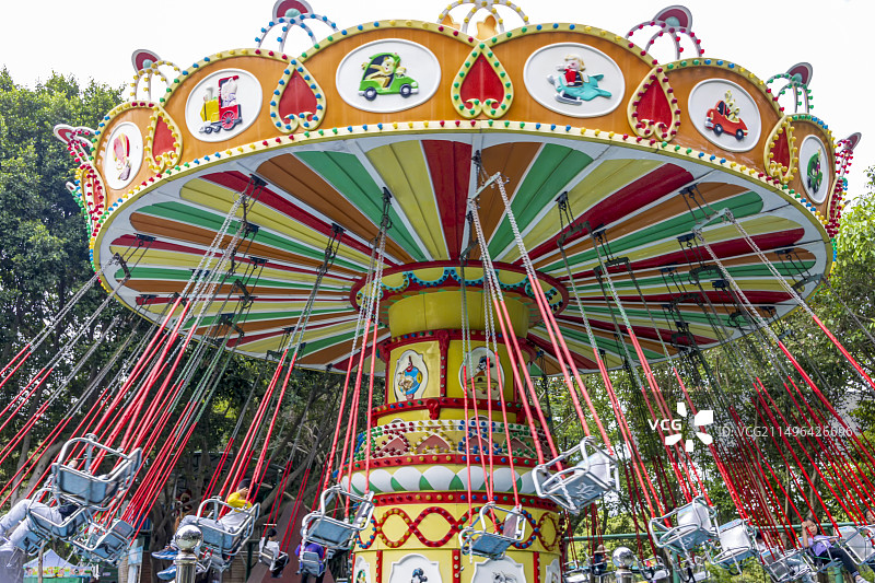 城市公园中五彩颜色的旋转秋千木马图片素材