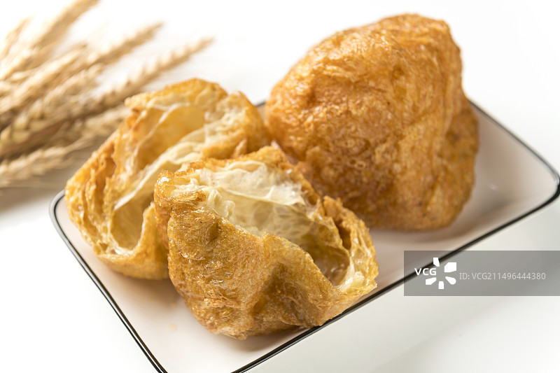 一盘油炸面筋摆放在桌面上特写图片素材