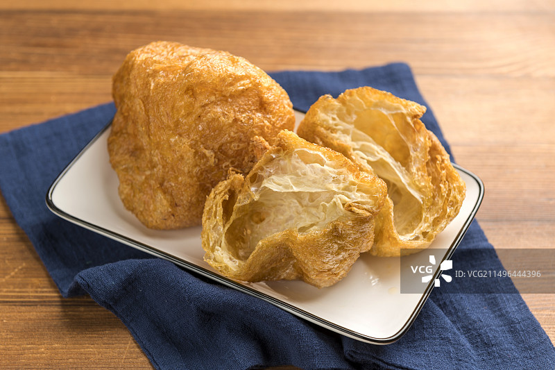 一盘油炸面筋摆放在桌面上特写图片素材