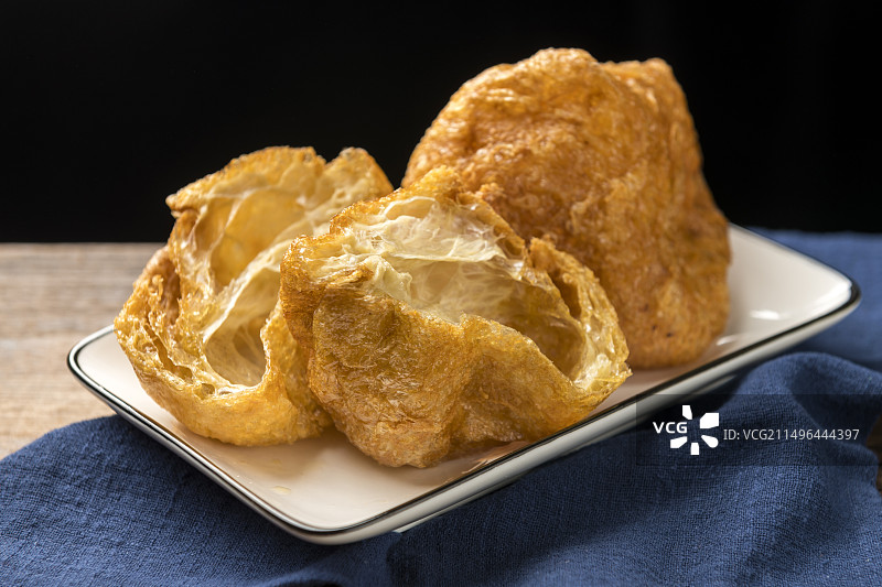 一盘油炸面筋摆放在桌面上特写图片素材