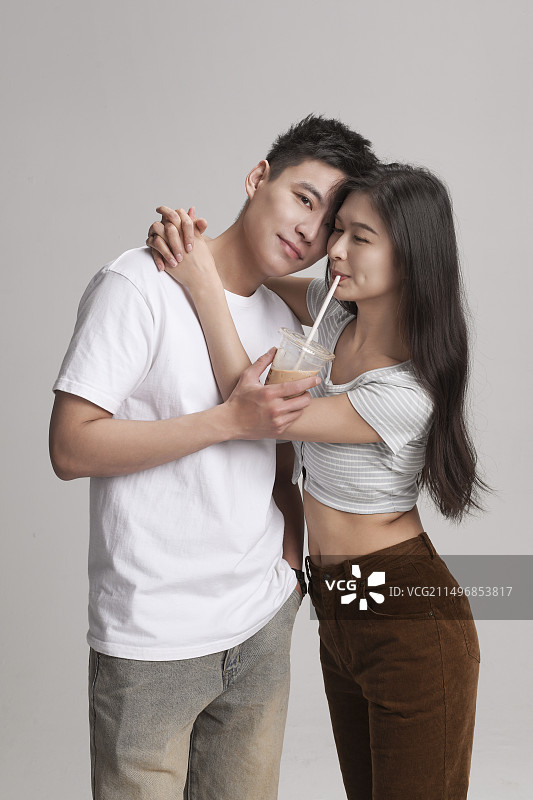 快乐的年轻情侣喝饮料 影棚拍摄图片素材