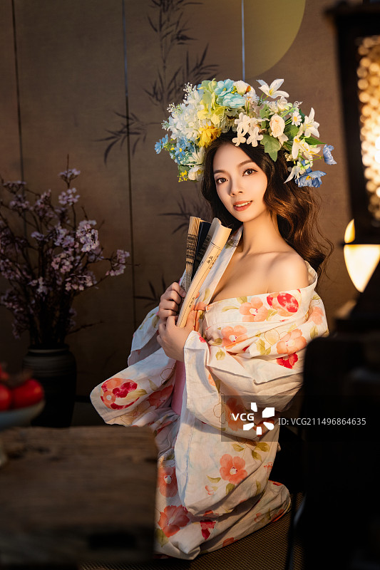 和服女子坐室内，樱花灯笼相映，花环扇子添雅韵，宁静温馨氛围浓图片素材