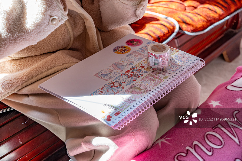 小女孩把手帐本放在膝盖上的特写镜头图片素材