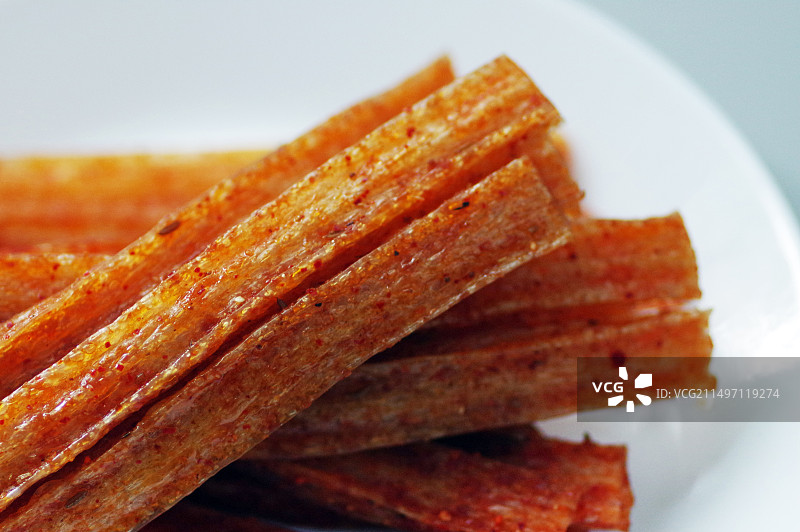 白色背景下白色盘子上的辣条特写图片图片素材