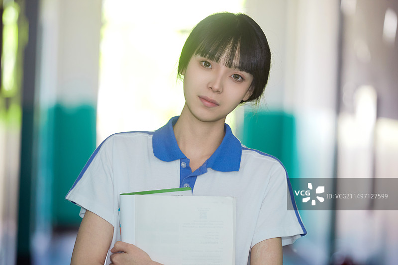 学校走廊里抱着书本的女高中生图片素材