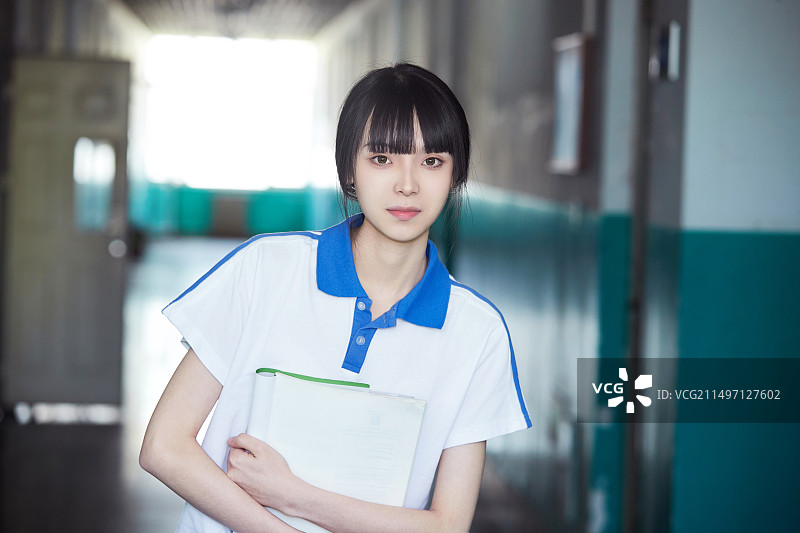 学校走廊里抱着书本的女高中生图片素材