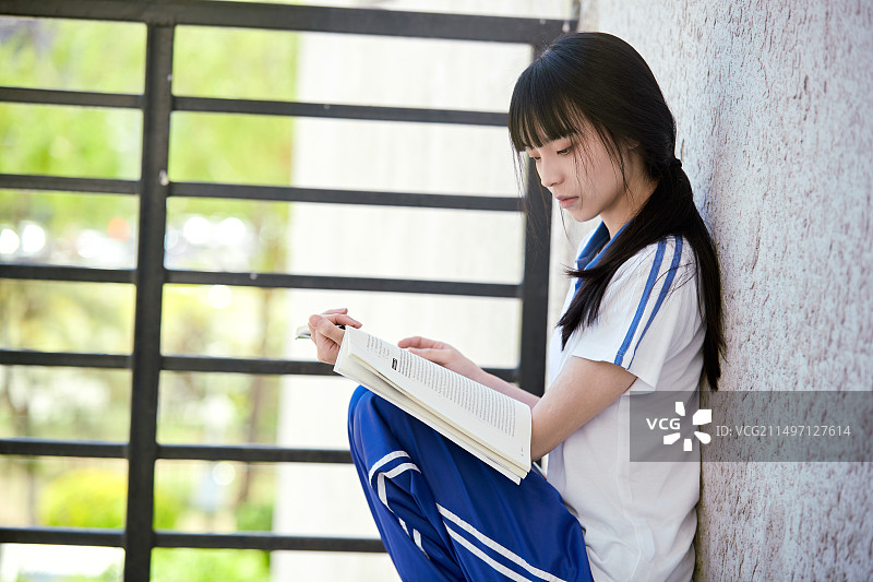 在学校教学楼阳台复习看书的高中生图片素材