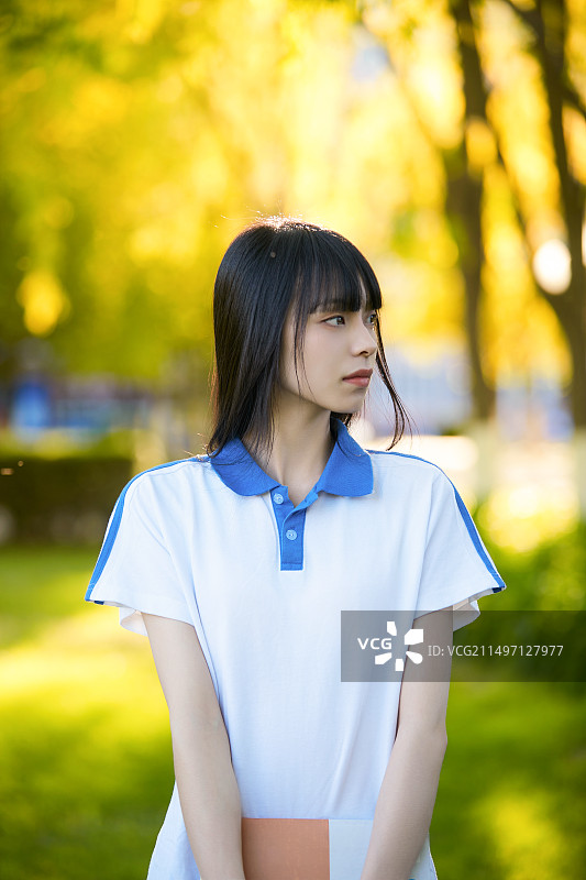 校园里抱着书的高中女生图片素材