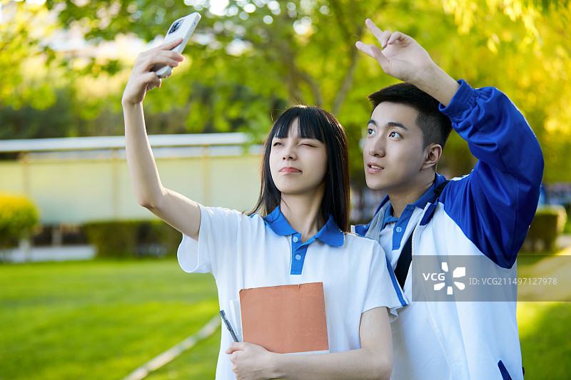校园里用手机自拍的高中生图片素材