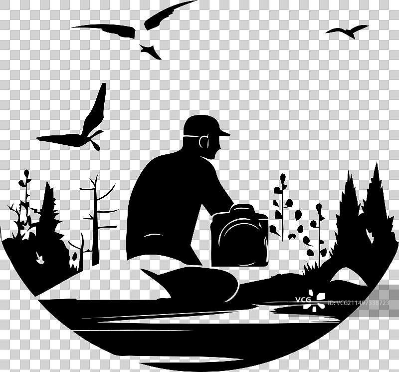 一名男子坐在湖边的岩石上图片素材