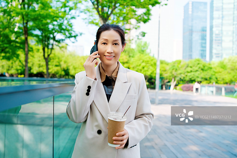 职业女性在咖啡休息时接电话图片素材