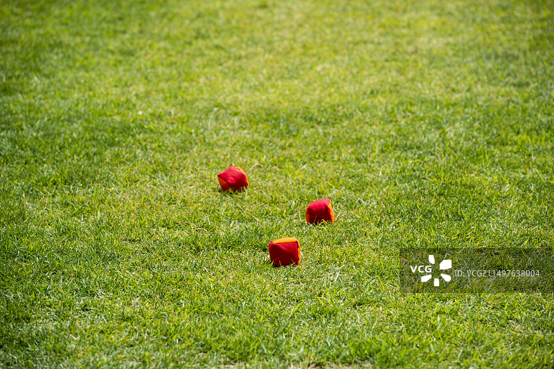 在草坪操场上的3个红色沙包图片素材