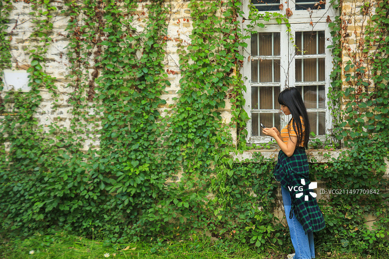 站在爬满藤蔓的墙前图片素材