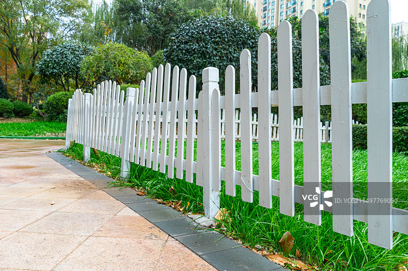 中国园林绿化带拍摄主题，公园的草坪上成一排的白色的木制篱笆选择对焦，户外白昼无人图像摄影图片素材