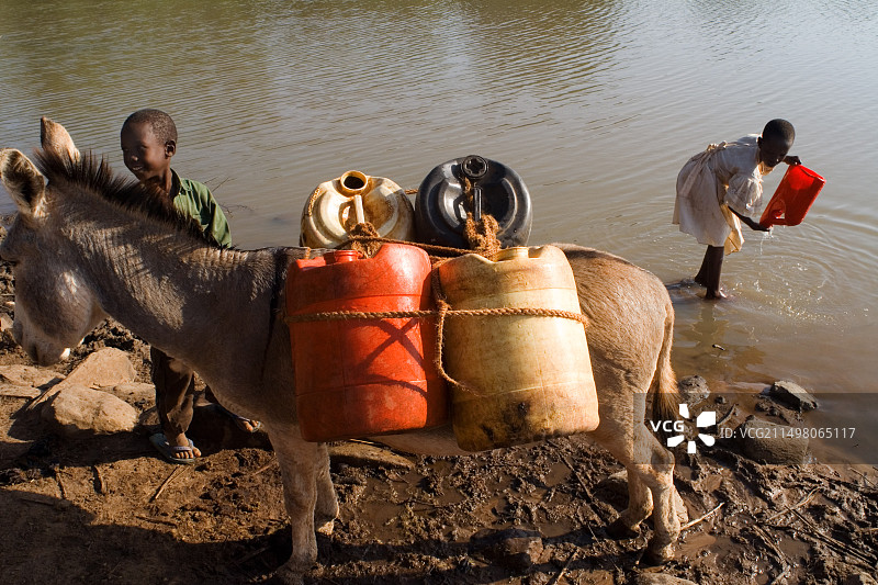 儿童从河里取水图片素材