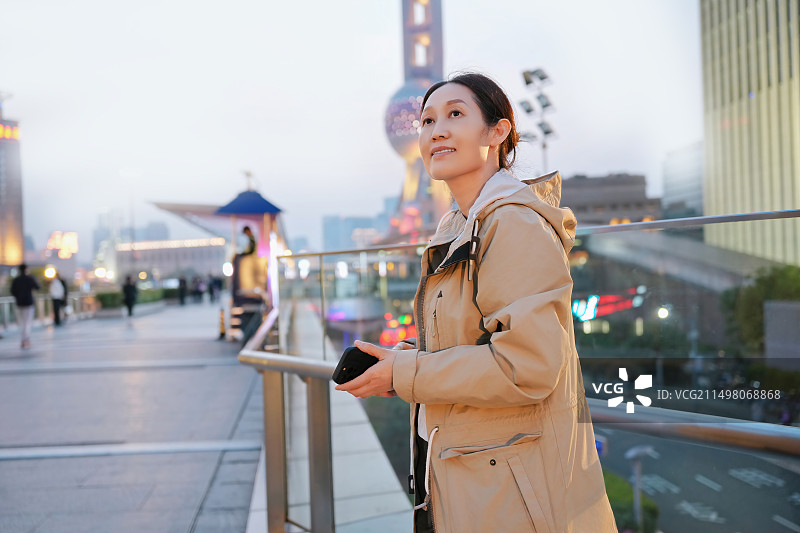 年轻女子黄昏户外探索城市景观图片素材