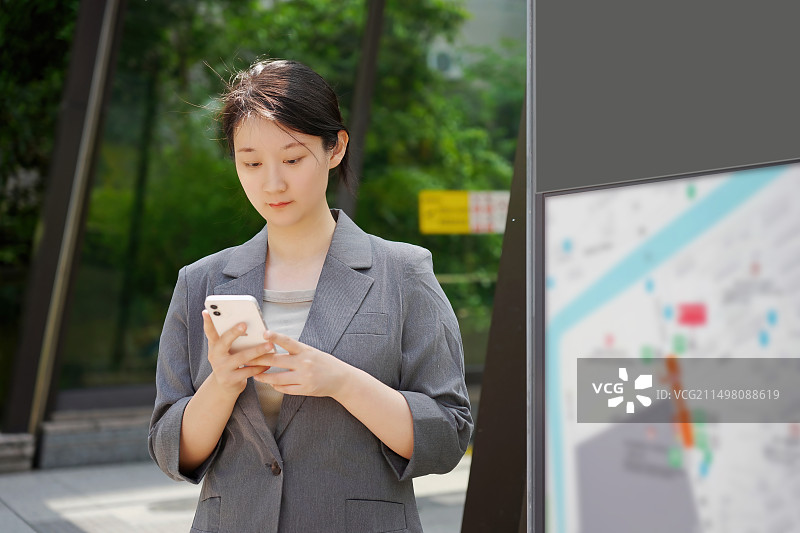 职业女性用智能手机在城市中导航图片素材