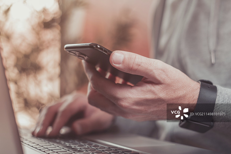 男人使用智能手机和笔记本电脑图片素材