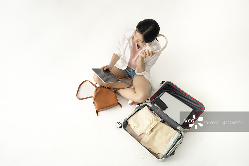 高角度下年轻女学生与打开的旅行箱图片素材