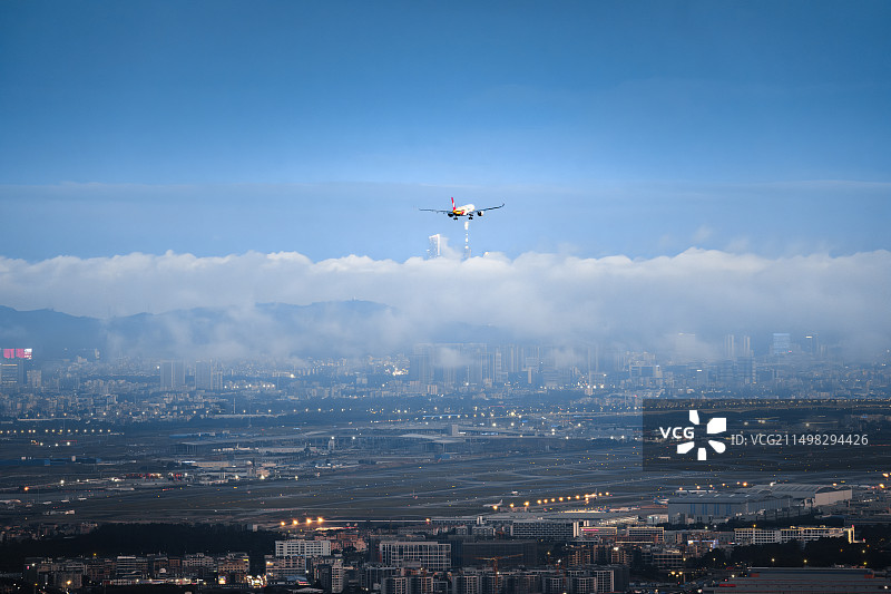 飞机在广州城市上空飞行的飞机图片素材