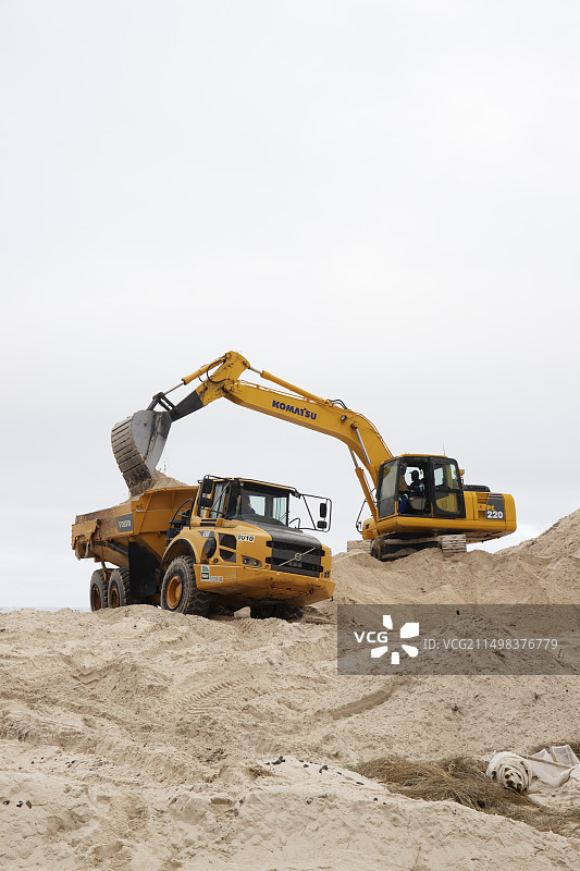 机械挖掘机重塑海岸沙丘图片素材