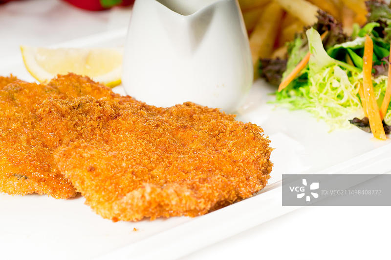 经典米兰炸小牛肉排配炸薯条和蔬菜图片素材