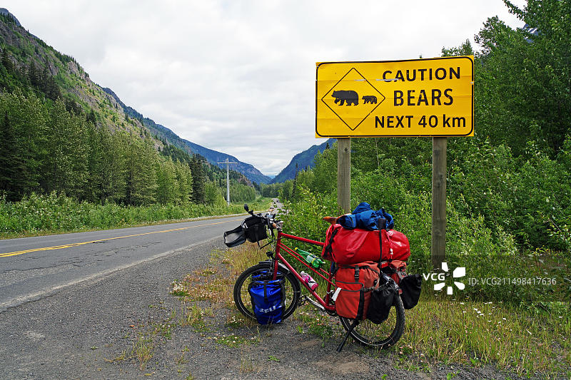 自行车停在警告前方40公里有熊出没的标志前，加拿大不列颠哥伦比亚省斯图尔特·卡西亚高速公路，北美图片素材
