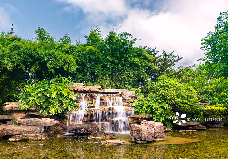 重庆渝北碧津公园景观-瀑布、假山和蓝天图片素材