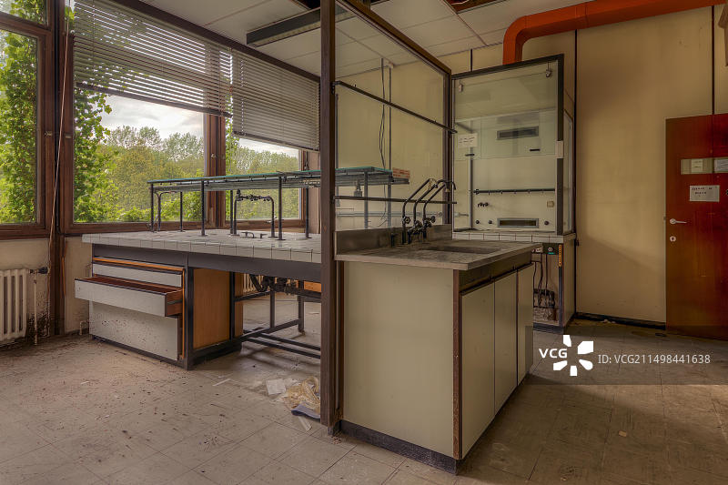 透过窗户可欣赏自然风光的空旷实验室，散落着纸屑，位于比利时圣热内西乌斯-罗德图片素材