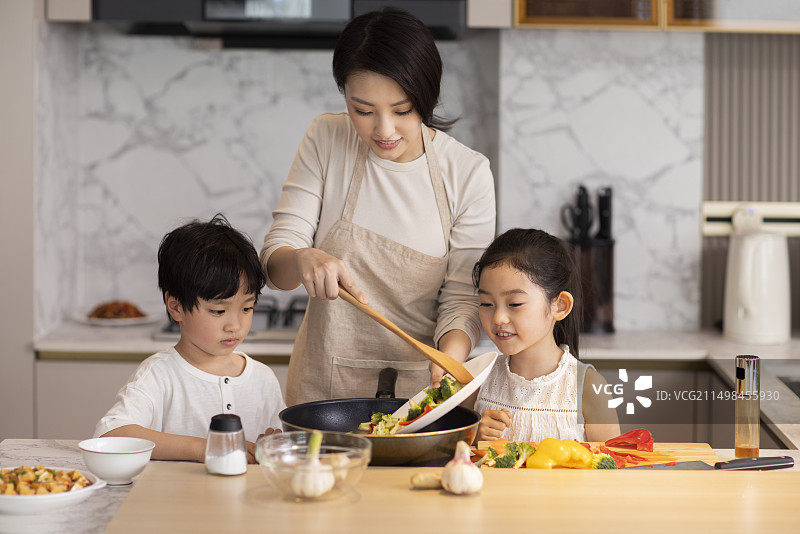 妈妈带俩孩子在厨房做饭图片素材