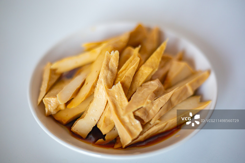 白色瓷盘里的凉拌五香酸浆豆干图片素材