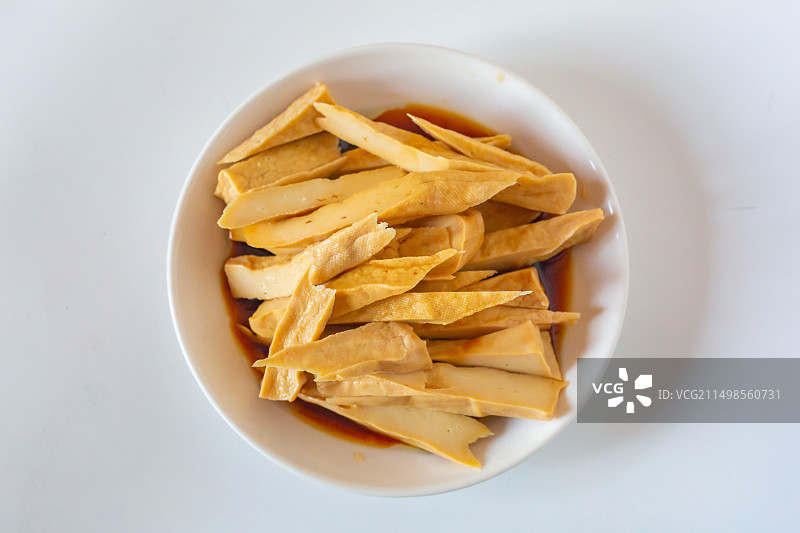 白色瓷盘里的凉拌五香酸浆豆干图片素材