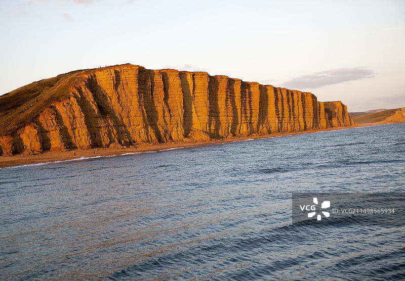 英国多塞特郡西湾东崖砂岩悬崖上的金色午后光线图片素材
