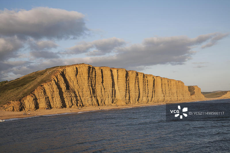 英国多塞特郡西湾东崖砂岩悬崖上的金色午后光线图片素材