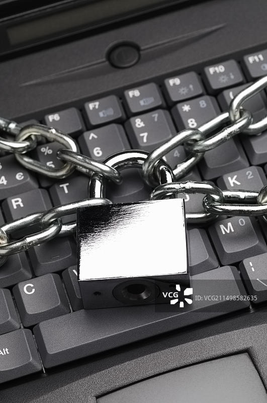 笔记本电脑键盘上的挂锁和链条图片素材