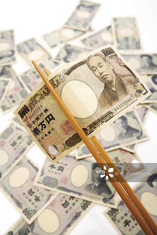 筷子夹着的10000日元纸币图片素材