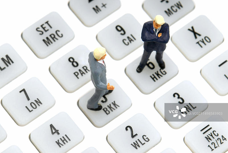 两个商人模型站在计算器上图片素材