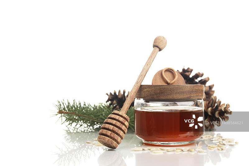 森林蜂蜜、蜂蜜勺和冷杉锥图片素材