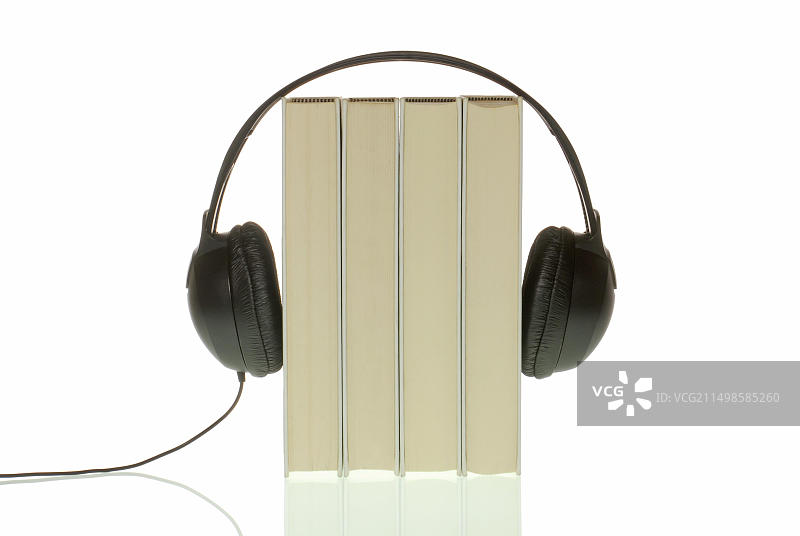 四本书上的耳机，有声读物的象征图片素材