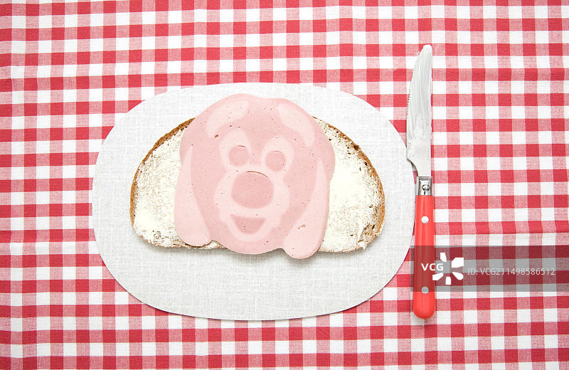 香肠做成脸状的三明治，砧板上的狗头和刀图片素材