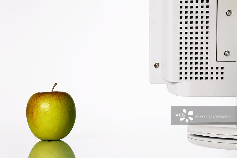 办公桌上电脑显示器旁的苹果图片素材
