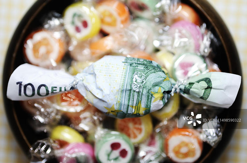 百元欧元钞票包裹的糖果，象征奖励图片素材