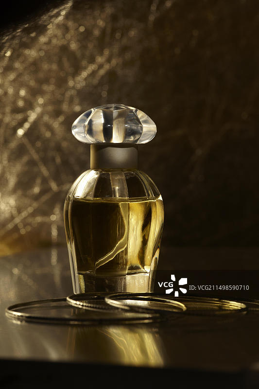 镜面上的香水瓶和金色手镯图片素材